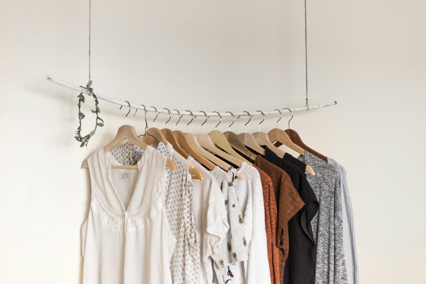 A woman selecting a neutral jacket from a well-organized everyday wardrobe